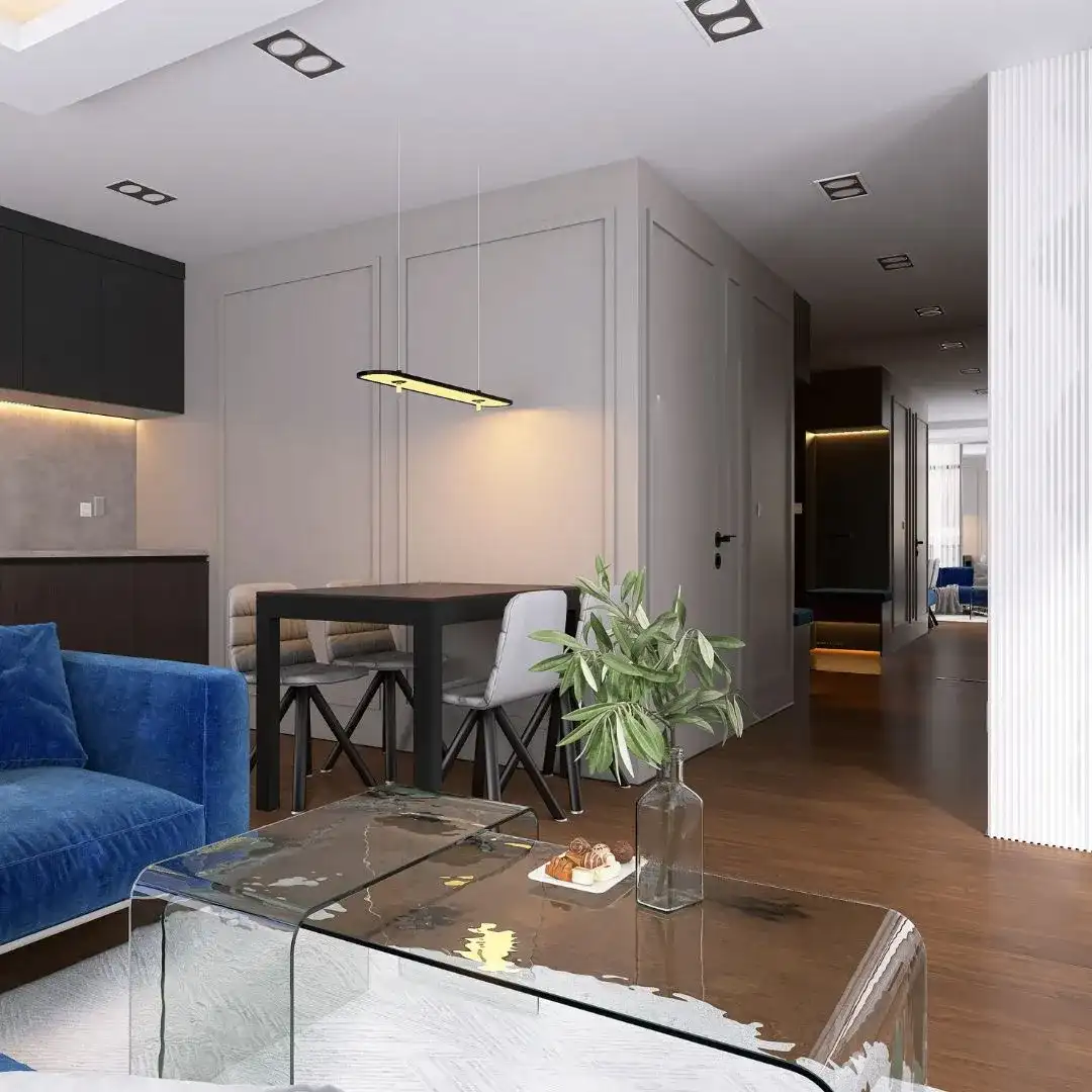 Elegancki salon z aneksem kuchennym z niebieską sofą i jadalnią, aranżacja wnętrz w Bydgoszczy